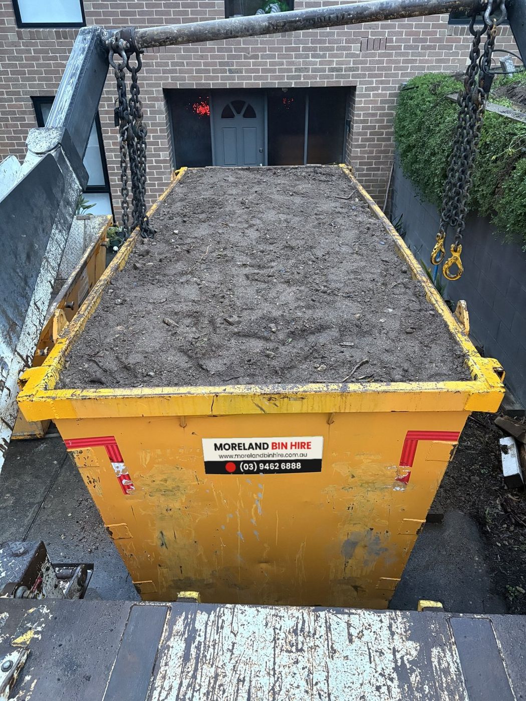 Moreland Bin Hire skip filled to the top with soil, ready for collection